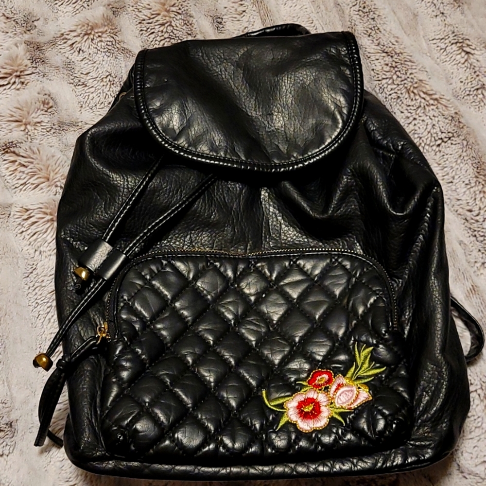 Black leather backpack with gold zipper and hardware